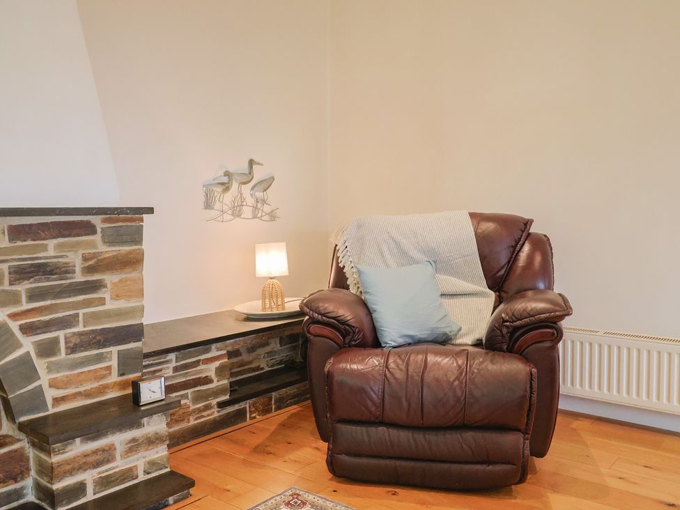 A living room with an armchair and lamp at Hawksdown in Lyme Regis