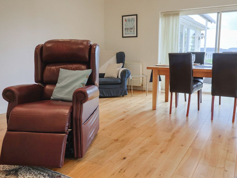 A living room with a reclining chair and dining table at Hawksdown in Lyme Regis