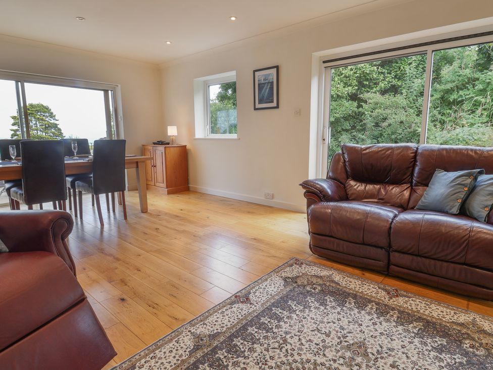 A living room with a sofa and dining area at Hawksdown in Lyme Regis