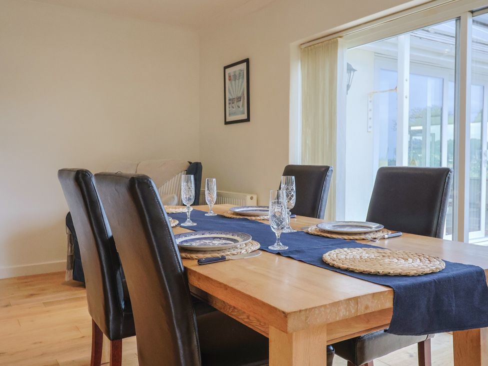 A dining room with a wooden table and chairs at Hawksdown in Lyme Regis