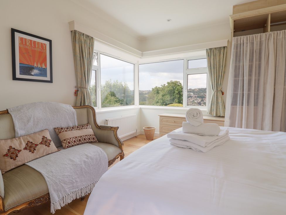 A bedroom with a sofa and towels on a bed at Hawksdown in Lyme Regis