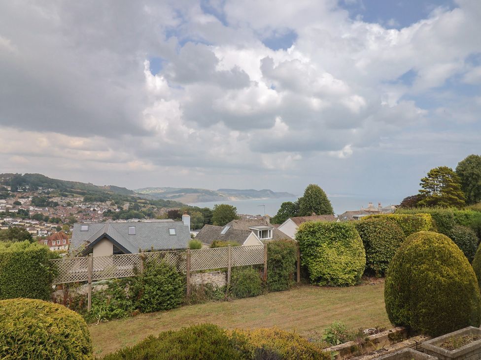 A view of houses and gardens with a coastline at Hawksdown in Lyme Regis