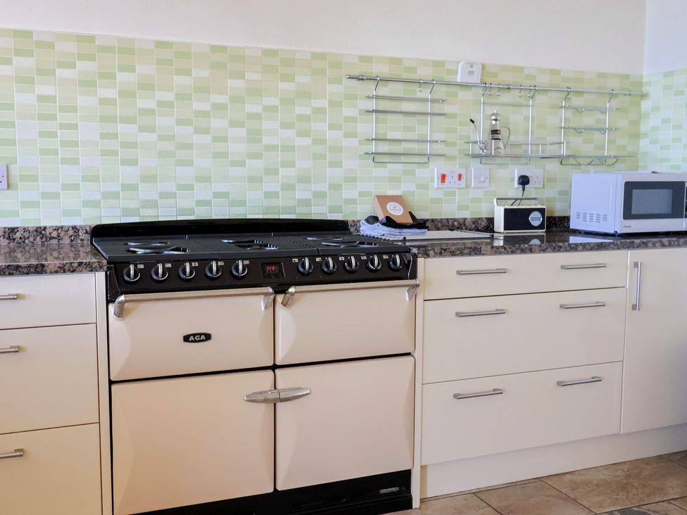 A kitchen with stove, microwave and countertop at Hawksdown in Lyme Regis