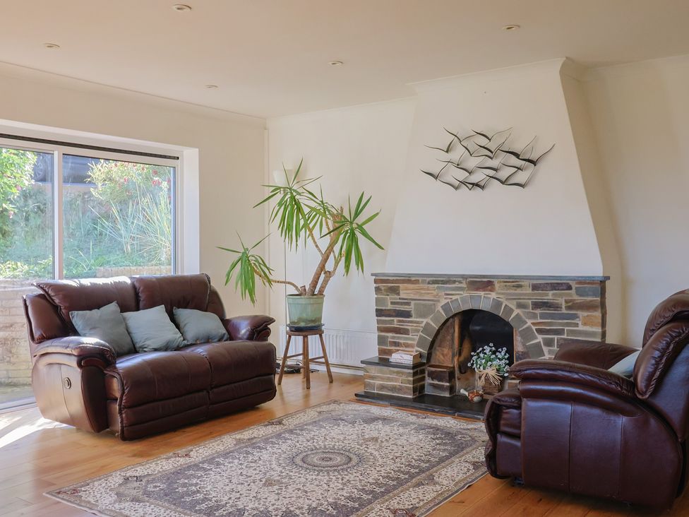A living room with a sofa and an armchair at Hawksdown in Lyme Regis