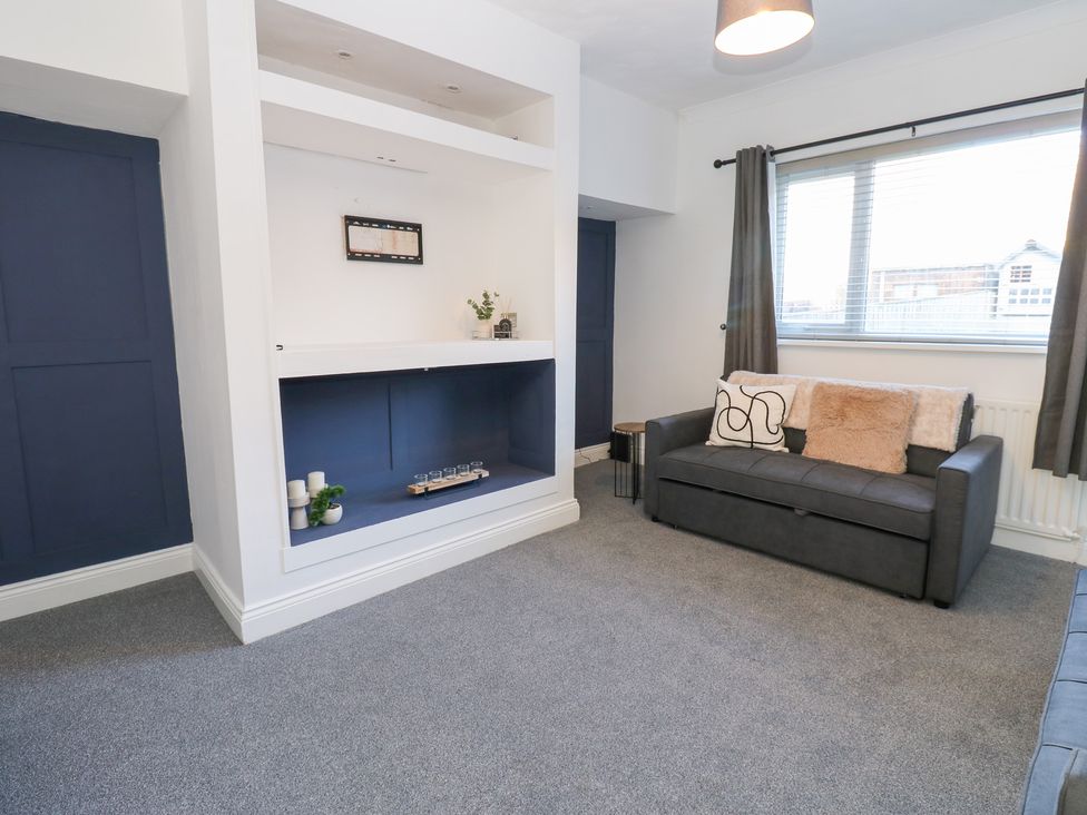A living room with a sofa and shelves at 16 Salvin Terrace in Stockton-on-Tees