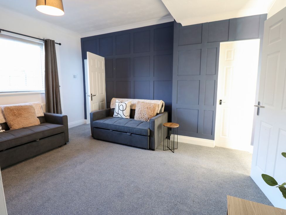 A living room with sofas and a side table at 16 Salvin Terrace in Stockton-on-Tees