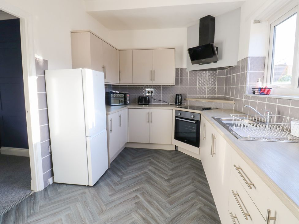A kitchen with a refrigerator, microwave, and oven at 16 Salvin Terrace, Stockton-on-Tees