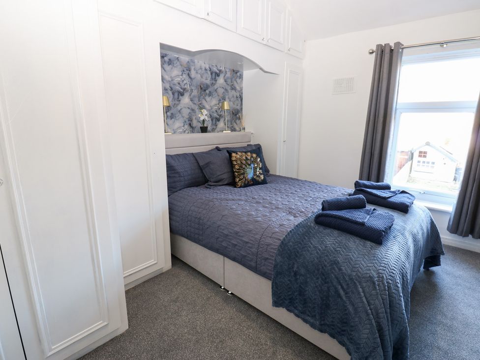 A bedroom with a bed, pillows, towels, and lamps at 16 Salvin Terrace in Stockton-on-Tees