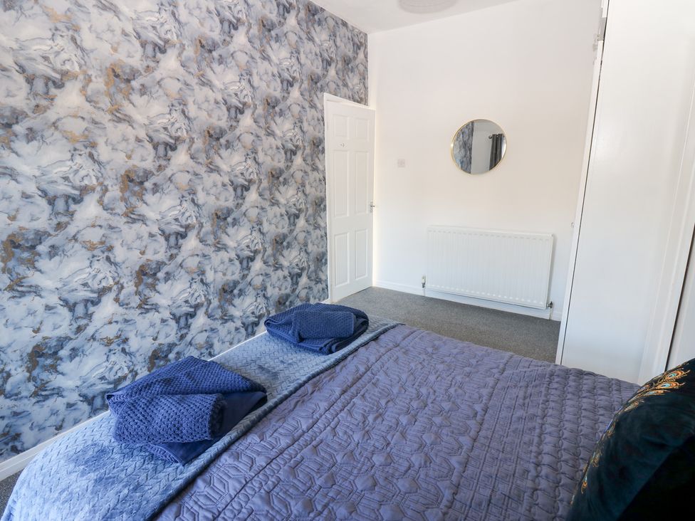 A bedroom with a bed and mirror at 16 Salvin Terrace in Stockton-on-Tees