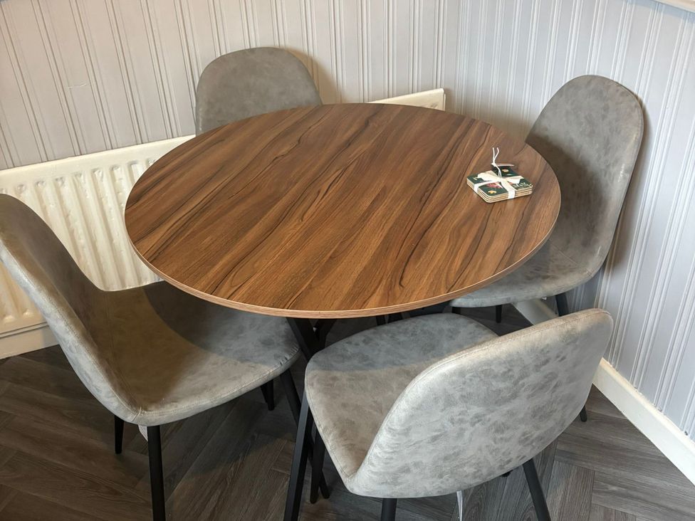 A dining room with a round table and four chairs at 16 Salvin Terrace Fishburn