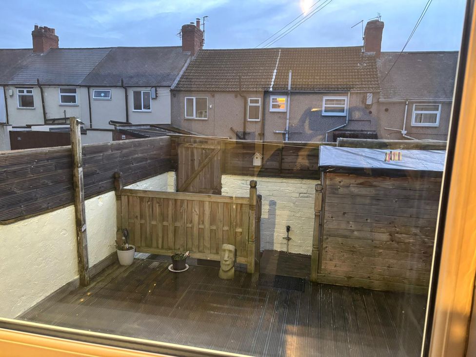 A garden area with wooden decking and a fence at 16 Salvin Terrace in Fishburn