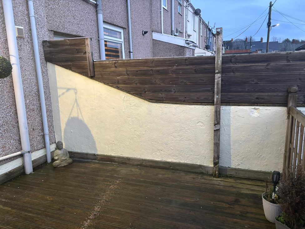 A garden area with decking and a buddha statue at 16 Salvin Terrace Fishburn