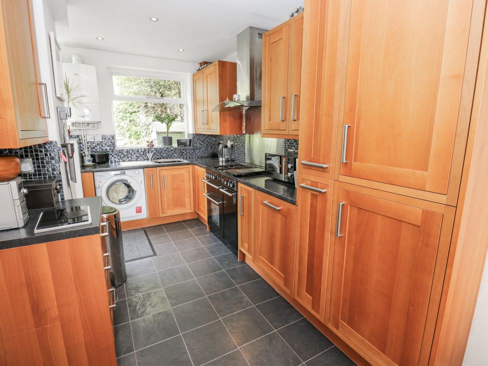 A kitchen with wooden cabinets and appliances at The Vista in Hebden Bridge