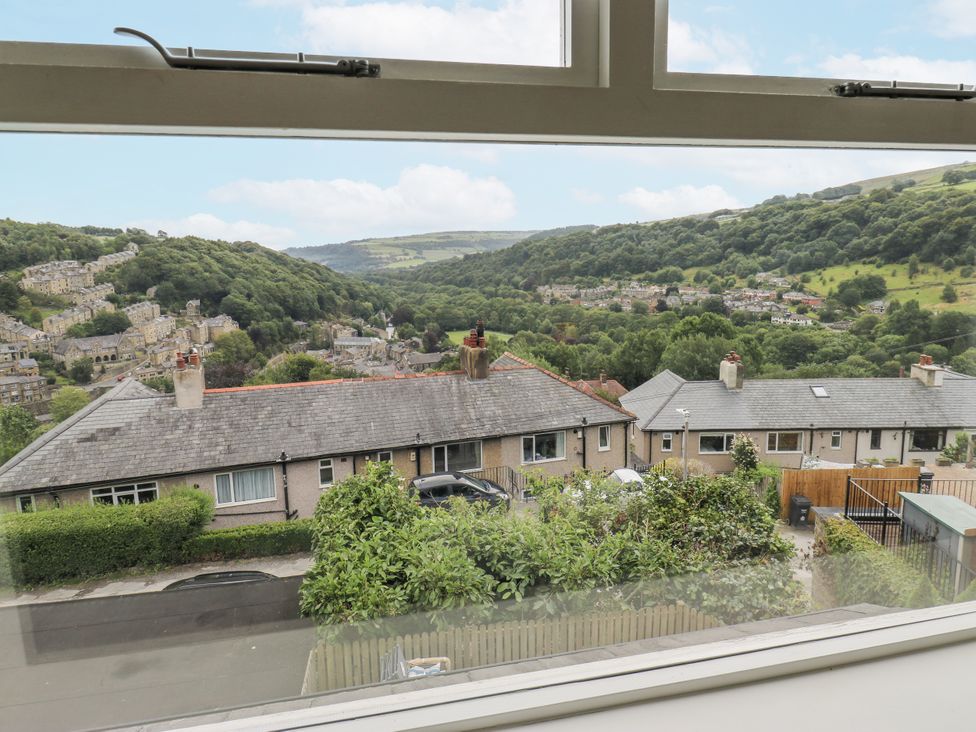 A view of houses and trees in the valley from a window at The Vista in Hebden Bridge