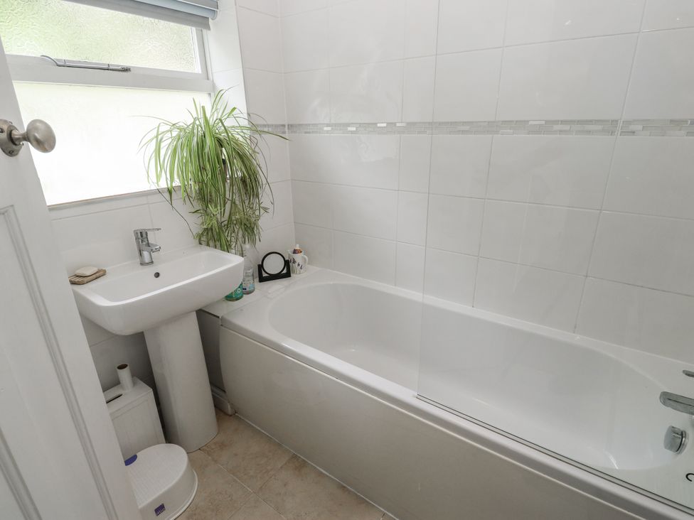 A bathroom with a bathtub, sink, and a plant at The Vista in Hebden Bridge