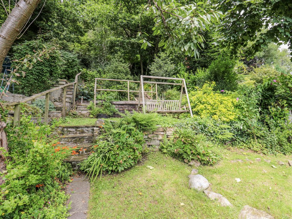 A garden with stairs and a wooden bench at The Vista in Hebden Bridge