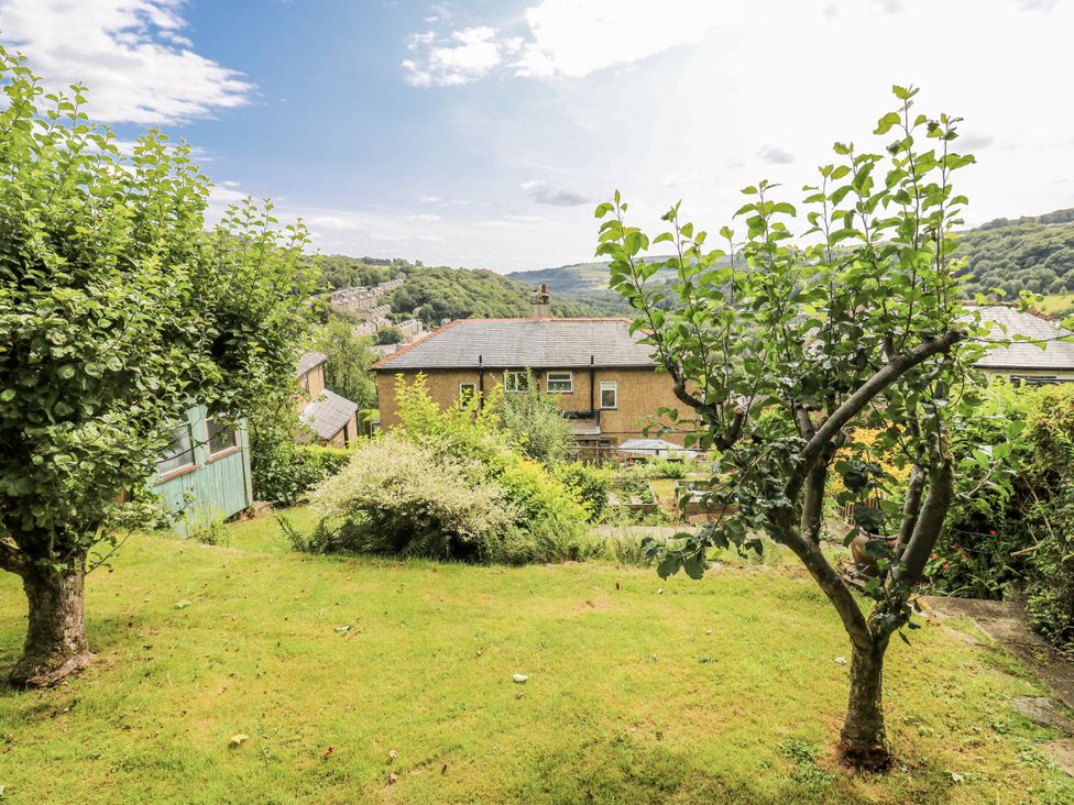 A garden with trees and a view of hills at The Vista in Hebden Bridge