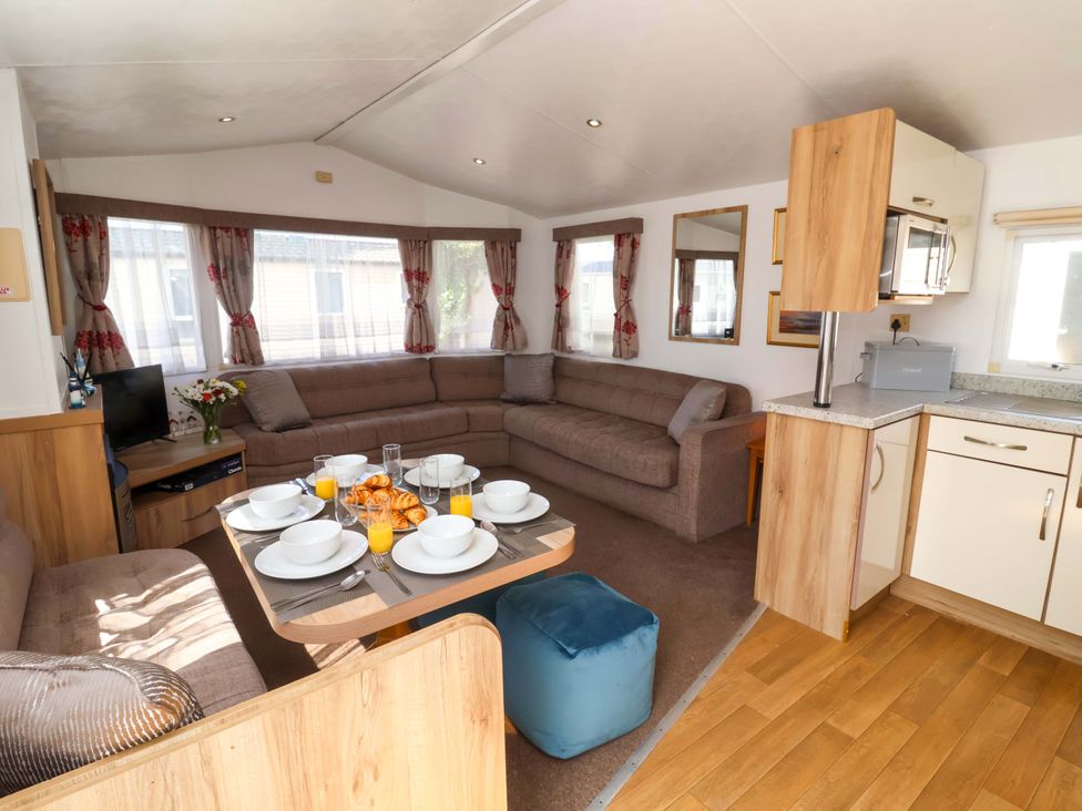 A living room with a couch and dining table at 21 Poplar Avenue in Felixstowe, Suffolk