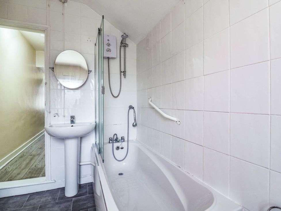 A bathroom with a bathtub, sink, and mirror at Dover Retreat in 
