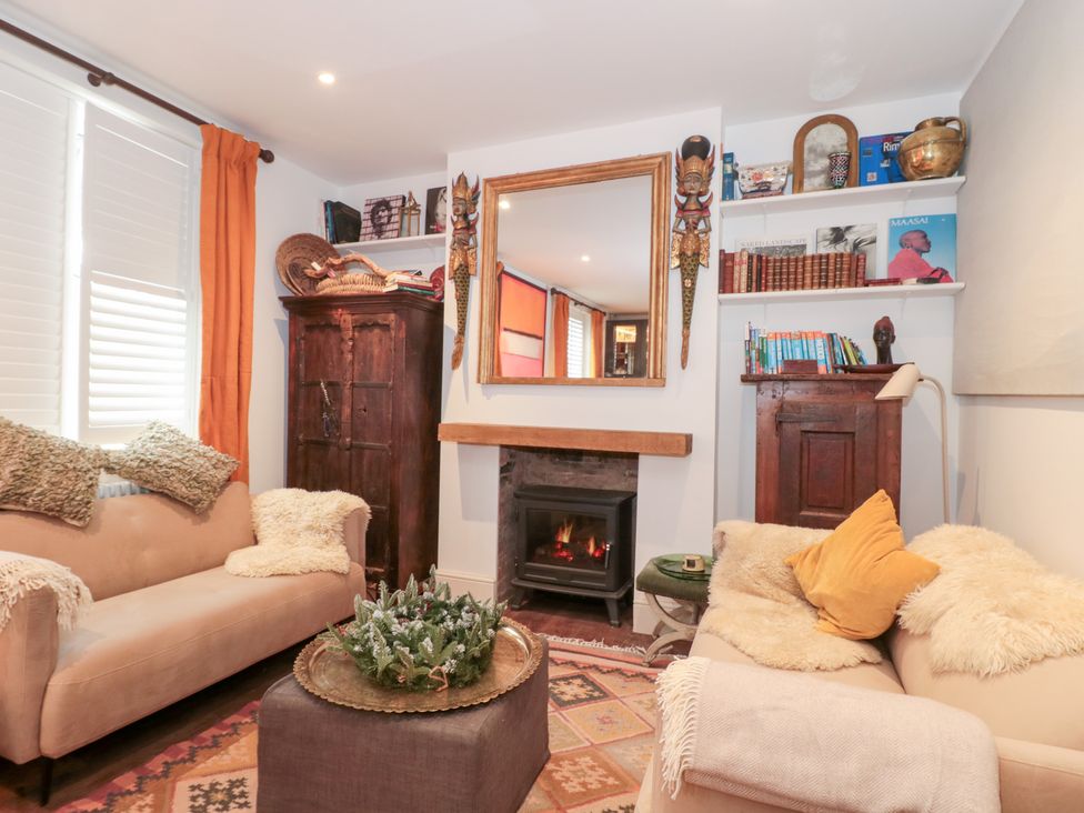 A living room with a fireplace and two sofas at Bohemian Beach Cottage in Bournemouth