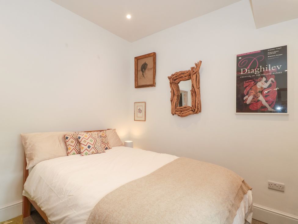 A bedroom with a bed and wall decorations at Bohemian Beach Cottage in Bournemouth