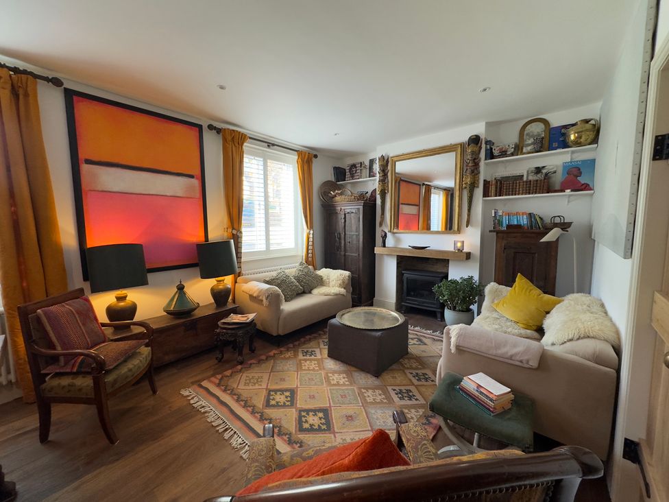 A living room with a sofa, armchair and fireplace at Bohemian Beach Cottage in Bournemouth