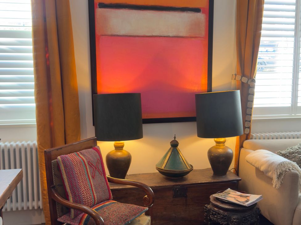 A living room with an armchair and lamps at Bohemian Beach Cottage in Bournemouth