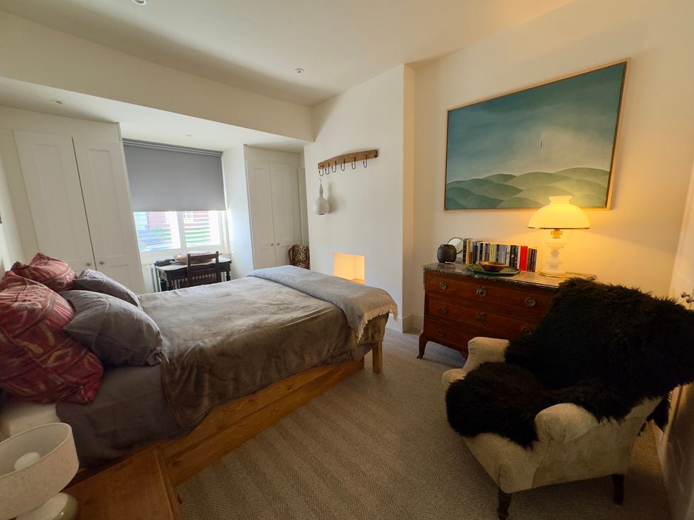 A bedroom with a bed, lamp, and desk at Bohemian Beach Cottage in Bournemouth