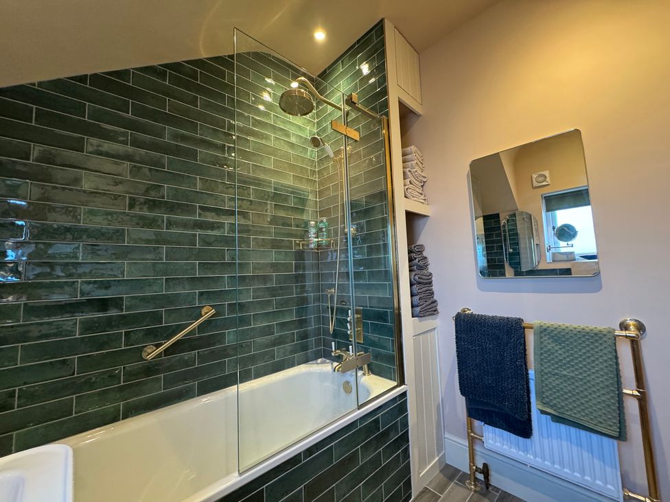 A bathroom with a shower and bathtub at Bohemian Beach Cottage Bournemouth