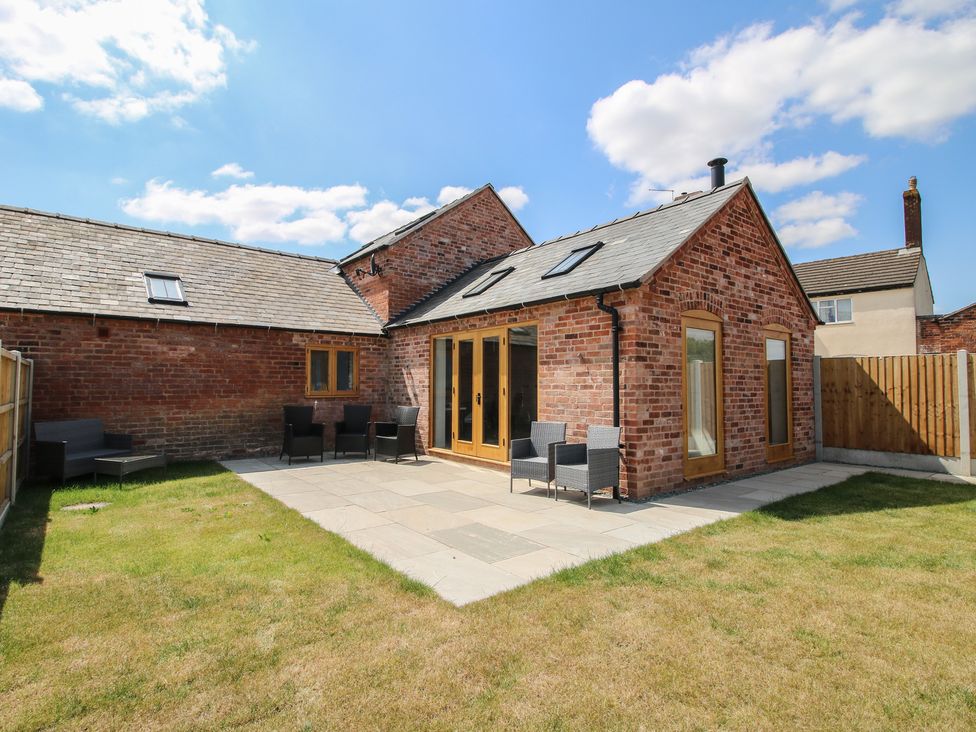 A garden with outdoor seating area and brick wall at Chestnut Barn Shrewsbury