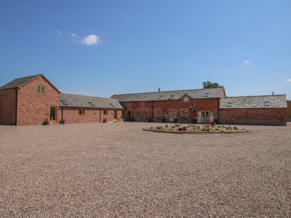 An outdoor area with brick buildings and a gravel courtyard at Chestnut Barn in Shrewsbury