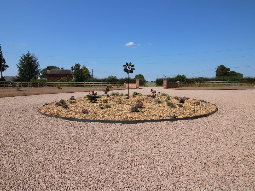 An outdoor area with a flower bed and ornamental windmill at Chestnut Barn in Shrewsbury