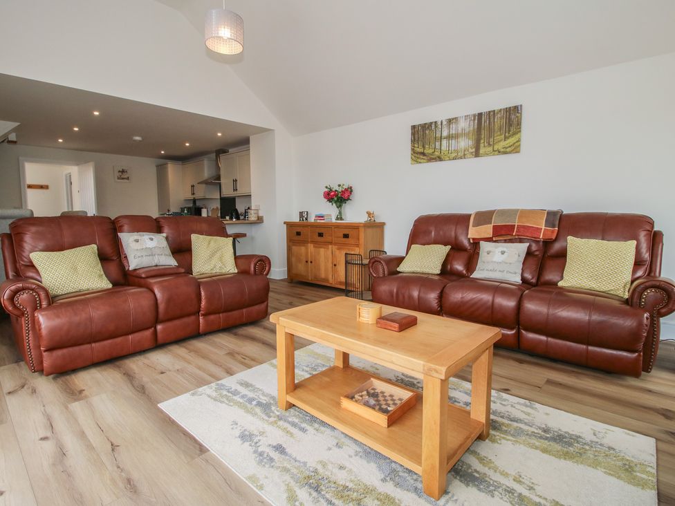 A living room with two brown sofas and a wooden coffee table at Chestnut Barn in Northwood near Wem