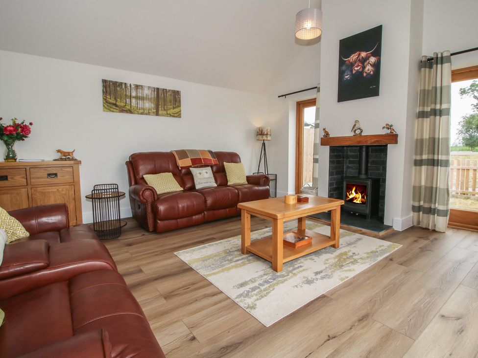 A living room with a fireplace and sofa at Chestnut Barn in Northwood near Wem