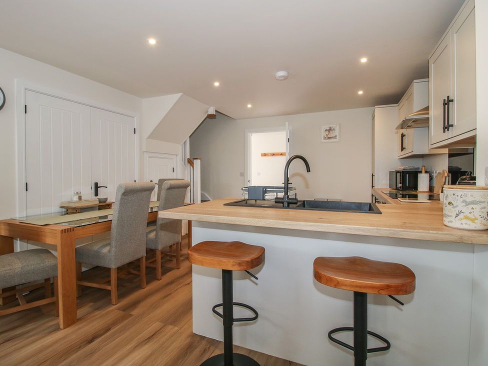 A kitchen with a dining area and stools at Chestnut Barn Northwood near Wem
