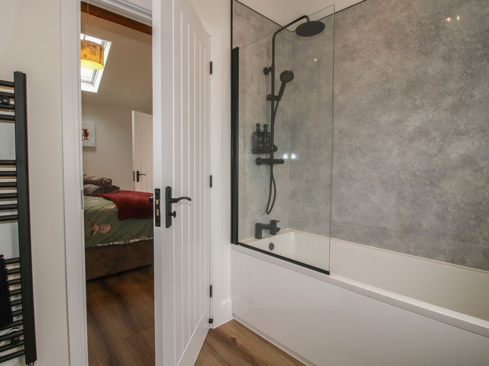 A bathroom with a bathtub and shower at Chestnut Barn near Wem