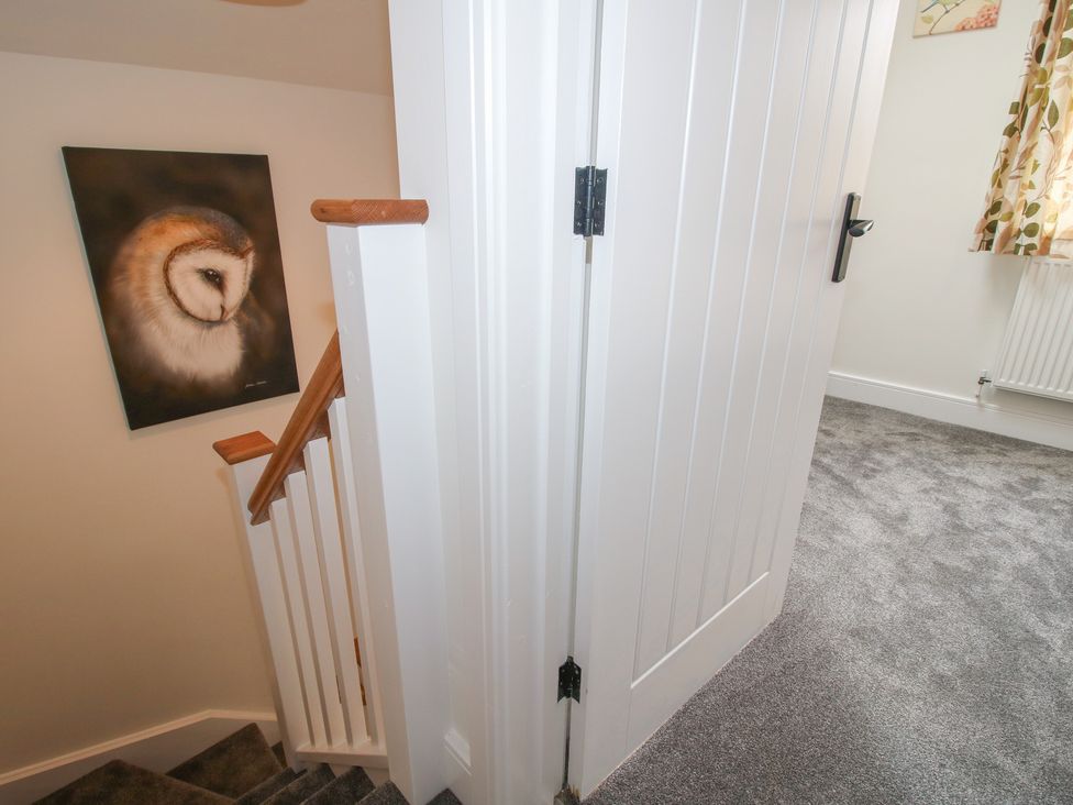 A staircase with a door and wall art at Chestnut Barn Northwood near Wem