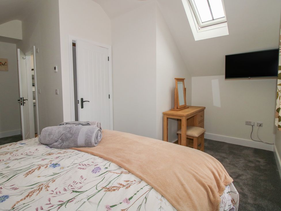 A bedroom with a bed and vanity table at Chestnut Barn near Wem