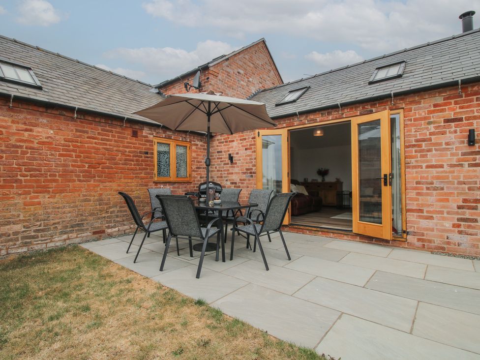 An outdoor seating area with a table and chairs at Chestnut Barn Northwood near Wem
