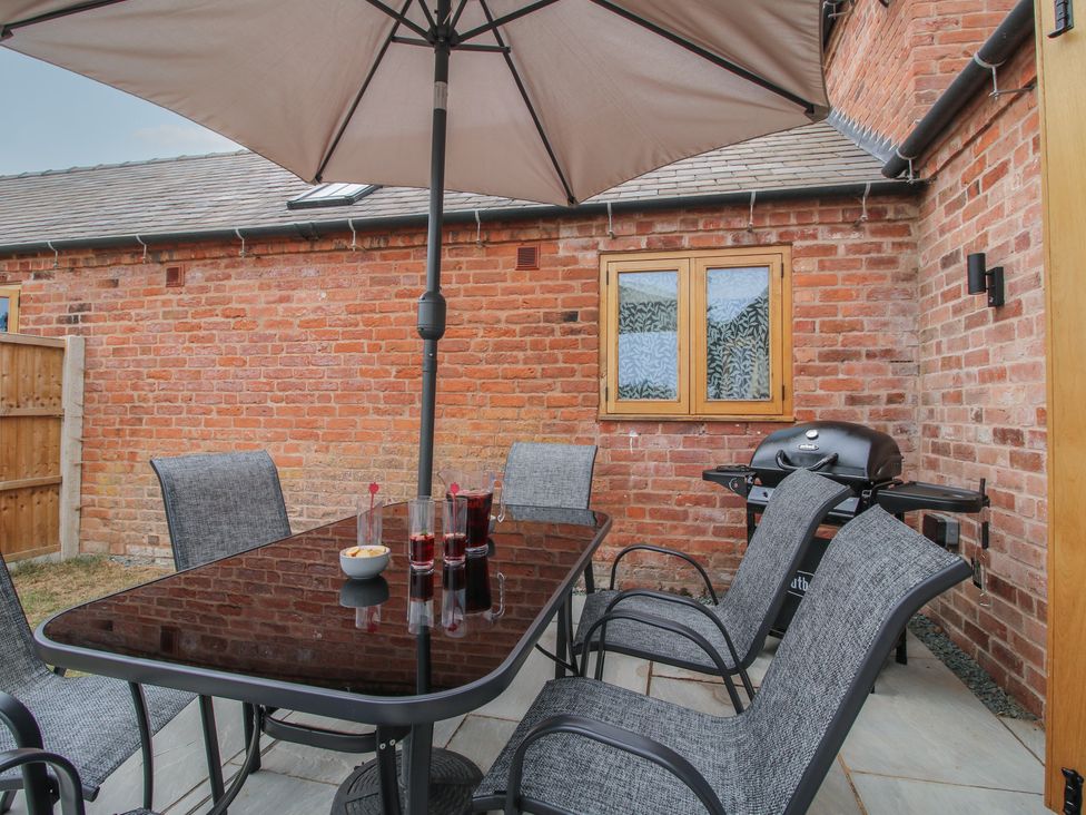 An outdoor dining area with a table and chairs at Chestnut Barn Northwood near Wem