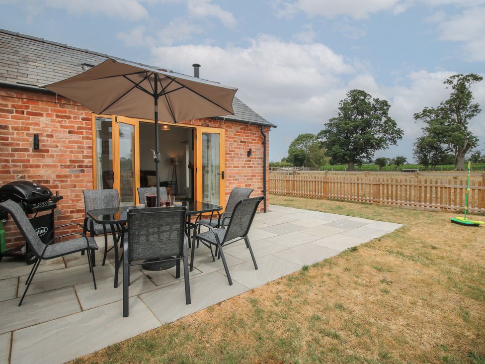 An outdoor patio with a table and chairs at Chestnut Barn in Northwood near Wem
