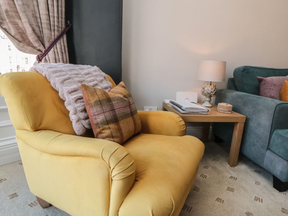 A living room with an armchair and sofa at Stanton House - Abbey View, Flat 3