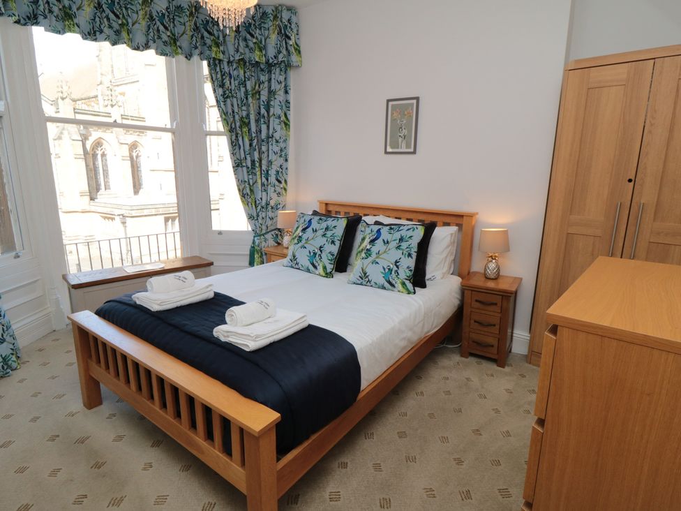 A bedroom with a bed, bedside table, and wardrobe at Stanton House - Abbey View, Flat 3