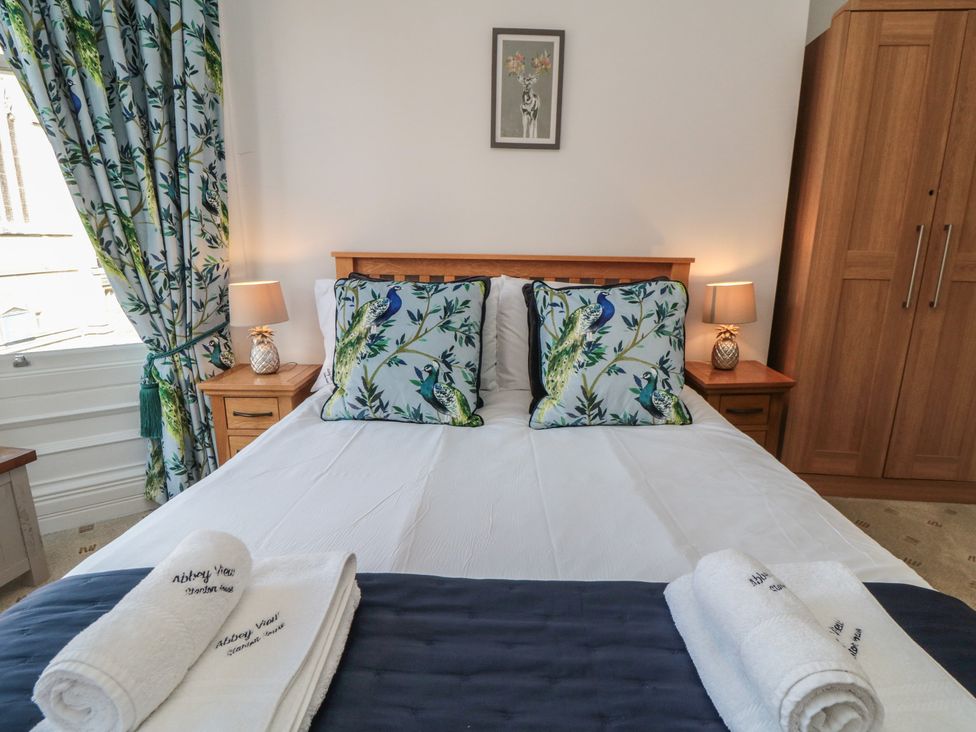 A bedroom with a bed and decorative pillows at Stanton House - Abbey View, Flat 3