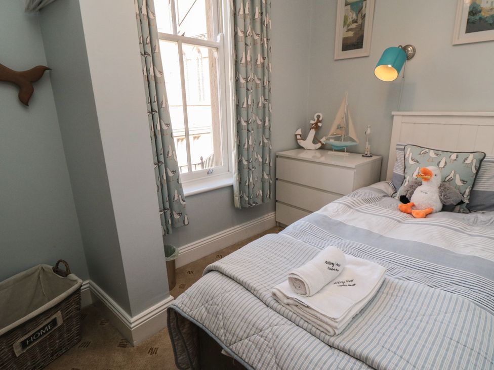 A bedroom with a bed and dresser at Stanton House - Abbey View, Flat 3