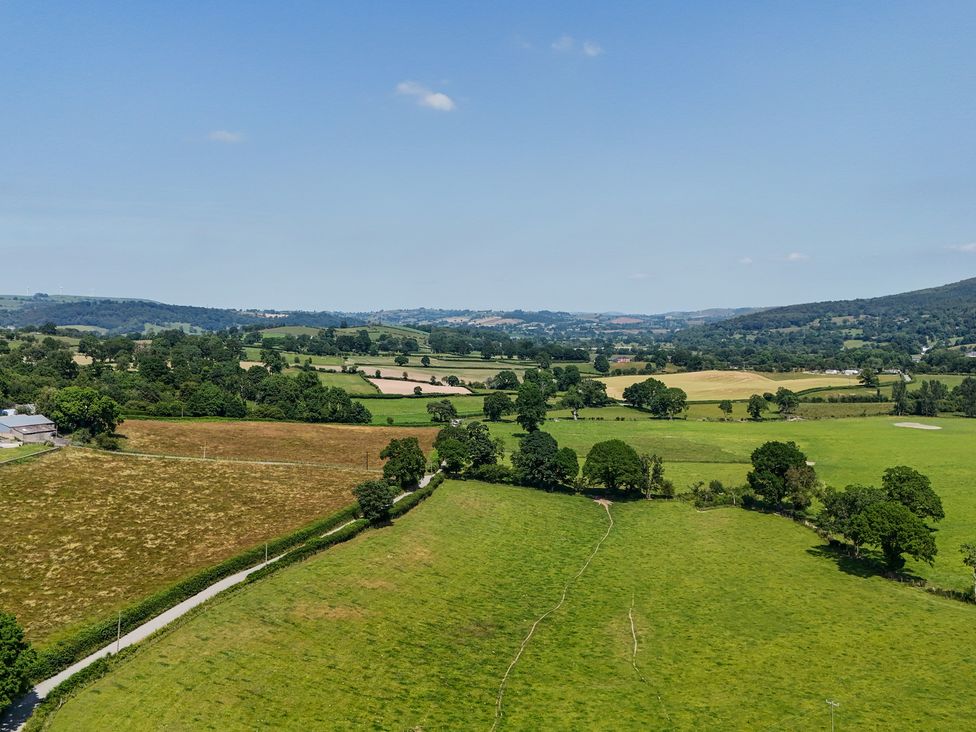 A landscape view with fields and trees at The Dairy in Corwen