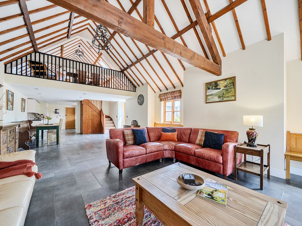 A living room with a sofa, coffee table and dining table at The Dairy in Corwen