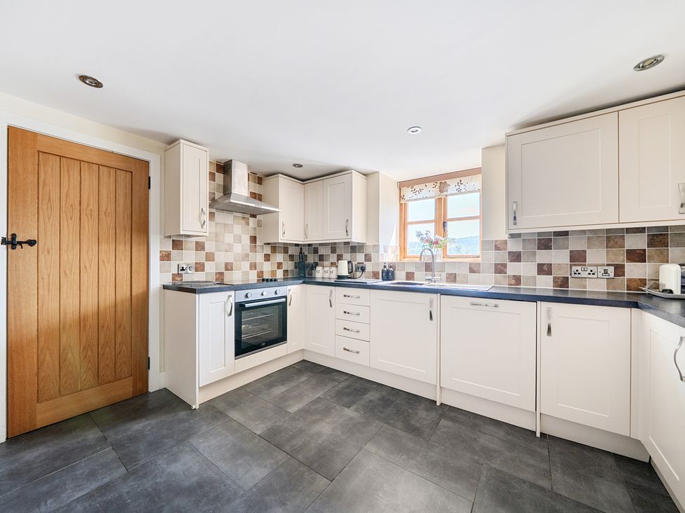 A kitchen with cabinets and appliances at The Dairy in Corwen