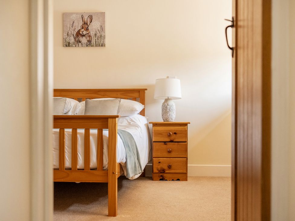 A bedroom with a bed and a nightstand at The Dairy in Corwen