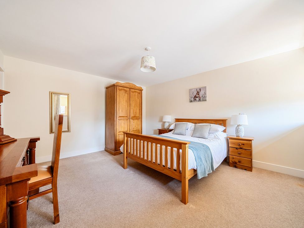 A bedroom with a bed and wardrobe at The Dairy in Corwen